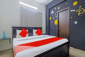 a bedroom with a bed with red and white pillows at OYO Rs Hotel Near Hitech City in Kondapur