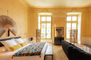 a bedroom with a bed and a couch and windows at Le Henri IV in Le Mans