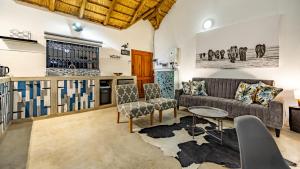 a living room with a couch and a table at Blue Goose Bush Retreat in Marloth Park