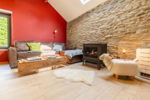 uma sala de estar com um sofá e uma parede de pedra em Gîte Bed & Bedot em Fauvillers