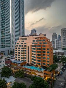 a building with a swimming pool in a city at The Mandison Bangkok - Formerly Golden Tulip Mandison Suites in Bangkok