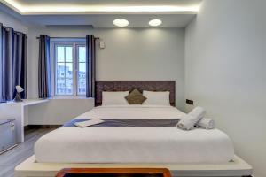 a bedroom with a large white bed in a room at Hotel Brundavan International Guntur in Guntūr