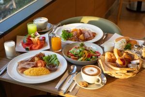 a table topped with plates of food and drinks at The Mandison Bangkok - Formerly Golden Tulip Mandison Suites in Bangkok