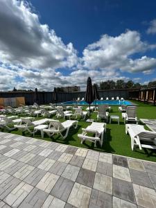 a group of white lounge chairs and a swimming pool at Hotel and Entertaiment Complex Vlada in Cherkasy