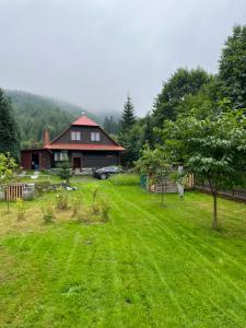 dom z zielonym ogródkiem przed nim w obiekcie Ludvíkova Chalupa w mieście Valašská Bystřice