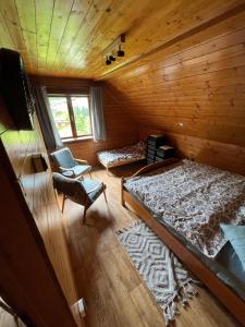 ein Schlafzimmer mit 2 Betten und einem Stuhl in einer Hütte in der Unterkunft Ludvíkova Chalupa in Valašská Bystřice