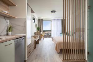 una cucina e una camera con letto e balcone. di Aetherion Studios & Suites a Kalivia Poligirou