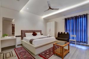 a bedroom with a king sized bed and a couch at Hotel Brundavan International Guntur in Guntūr