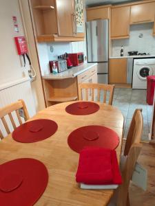 a kitchen with a wooden table with red napkins on it at Basildon Holiday Home in Essex UK in Laindon