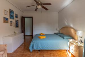 sypialnia z niebieskim łóżkiem i wentylatorem sufitowym w obiekcie Apartment Marzipans'Oasis w San Miguel de Abona