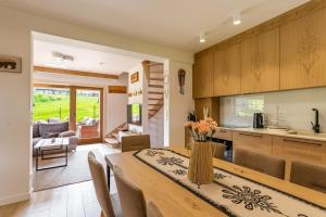 a kitchen and dining room with a table and chairs at Rogata Chata Premium, Kościelisko in Kościelisko