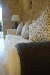Miss Nefeli - Marvelous Stone Apartment in Perdika-Aegina في ايجينا تاون: غرفة نوم بسرير مع مخدات ومصباح