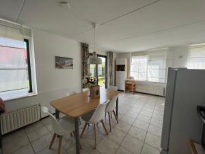a kitchen and dining room with a wooden table and chairs at Hello Zeeland - Vakantiehuis Stern 207 in Breskens