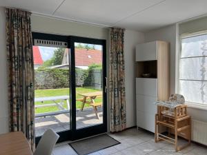 a kitchen with a sliding glass door to a patio at Hello Zeeland - Vakantiehuis Stern 207 in Breskens