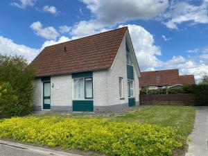 a white house with a brown roof at Hello Zeeland - Vakantiehuis Stern 207 in Breskens
