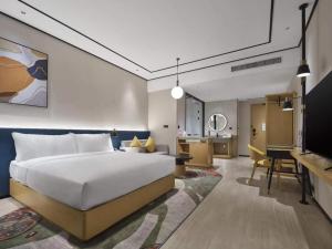 a bedroom with a bed and a living room at Hilton Garden Inn Tianjin Huayuan in Tianjin +29 photos