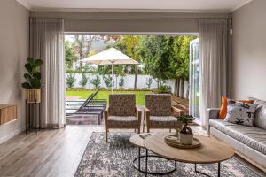 a living room with a couch and chairs and a table at Villa Stellenbosch in Stellenbosch