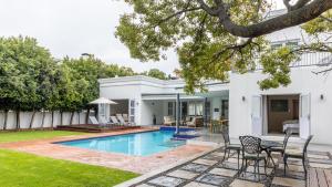 a backyard with a swimming pool and a house at Villa Stellenbosch in Stellenbosch
