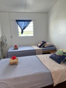 three beds in a room with a window at Room With A View & Apartment Style in Port Vila