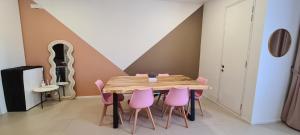 a dining room with a wooden table and pink chairs at Arcoris Mont Kiara 163 in Kuala Lumpur