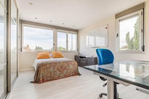 Schlafzimmer mit einem Bett, einem Schreibtisch und einem Glastisch in der Unterkunft Villa Oasis en Madrid con 3Hab, 4baños y elegante piscina in Villanueva del Pardillo + 34 Fotos