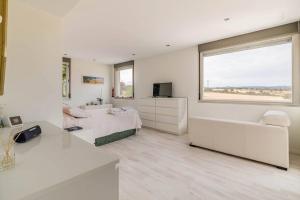 een witte slaapkamer met een bed en een raam bij Oasis en Madrid con 3Hab, 4baños y Piscina Lujosa! in Villanueva del Pardillo