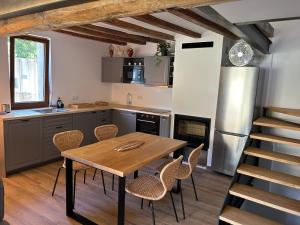 uma cozinha com uma mesa de madeira e cadeiras em El Molí - Apartament Torreneules em Ribes de Freser