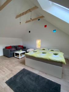 ein Schlafzimmer mit einem Bett und einer Couch in einem Zimmer in der Unterkunft Apartmán Králíček na vínné stezce in Dolní Bojanovice