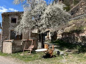 una casa de piedra con una mesa y sillas delante de ella en El Molí - Apartament Torreneules, en Ribes de Freser