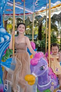 Una donna e un bambino su una giostra di Sheraton Sanya Haitang Bay Resort a Sanya