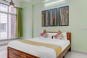 OYO Home Dazzling Studios Near Airport Near Pune Airport في Lohogaon: غرفة نوم بسرير كبير في غرفة