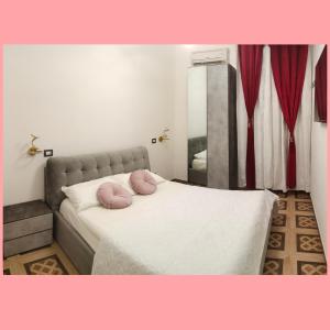 una camera da letto con un letto con due cuscini rosa di Rosa Italia Hotel Roma a Roma