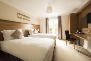 a hotel room with two beds and a desk at Riverside Hotel in Sligo