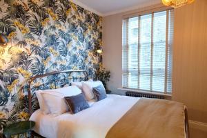 a bedroom with a bed with a floral wallpaper at Lovely 2-bedroom apartment in Shoreditch in London