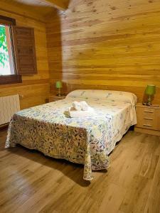 a bedroom with a bed in a wooden room at Complejo Rural La Tejera in Elche de la Sierra