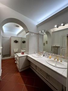 Appartamento in fattoria في بستويا: حمام به مغسلتين ومرآة كبيرة
