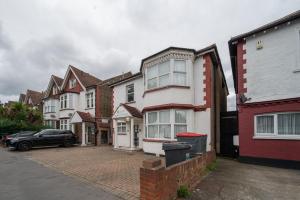 una fila de casas con un coche aparcado en una entrada en Flexistay Norbury Aparthotel, en Londres