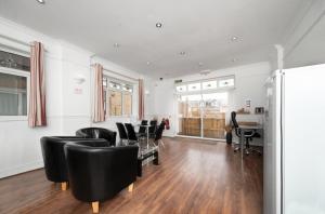 - un salon avec des chaises noires et du parquet dans l'établissement Flexistay Norbury Aparthotel, à Londres