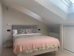 ein Schlafzimmer mit einem großen Bett mit einer rosa Decke in der Unterkunft EL ARCO DE LA CATEDRAL in Burgos
