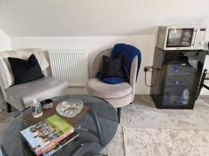 a living room with a glass table and two chairs at Hillvine in Hartpury