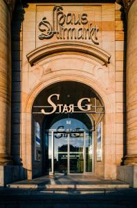 Star G Hotel Premium Dresden Altmarkt في درسدن: محل امام مبنى عليه لافته