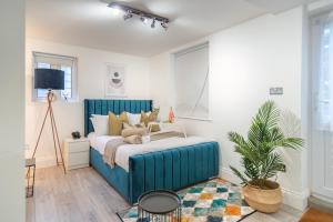 a bedroom with a blue bed in a room at Livestay-Funky Trendy Modern 3 Bed 3 Bath House In Dalston in London