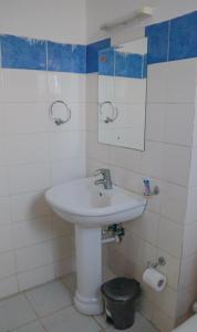 a bathroom with a white sink and a mirror at Cozzy homestyle in Nairobi