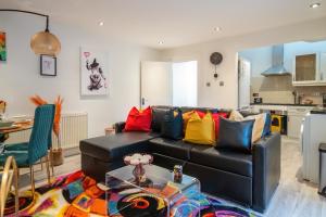 sala de estar con sofá negro y almohadas coloridas en Livestay-Funky Trendy Modern 3 Bed 3 Bath House In Dalston en Londres