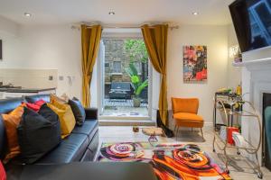 a living room with a blue couch and a window at Livestay-Funky Trendy Modern 3 Bed 3 Bath House In Dalston in London