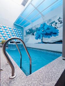 uma piscina com um mural de uma árvore em Star Villa 2 em Angeles