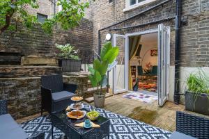 a patio with a table with food on it at Livestay-Funky Trendy Modern 3 Bed 3 Bath House In Dalston in London