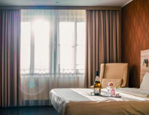 a hotel room with a bed and a bottle of beer at Star G Hotel Premium Dresden Altmarkt in Dresden