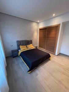 a bedroom with a bed and a wooden floor at Superbe appartement à mohammadia in Mohammedia +38 photos