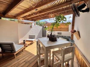 a patio with a table and chairs on a deck at Ti Kaloo, 2ème ligne, 40 m du Lagon in Saint-Leu